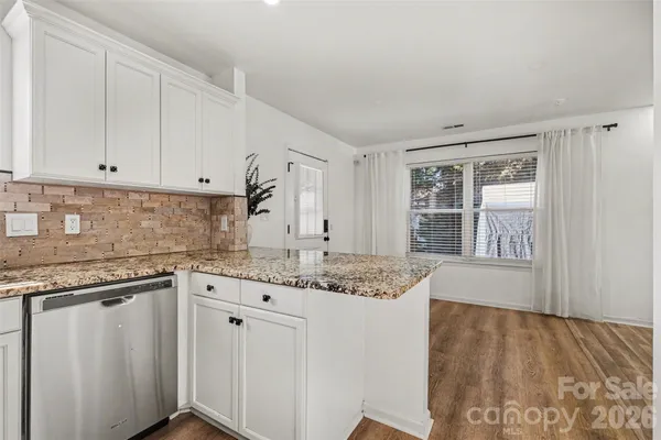 a kitchen with granite countertop a refrigerator stove and microwave