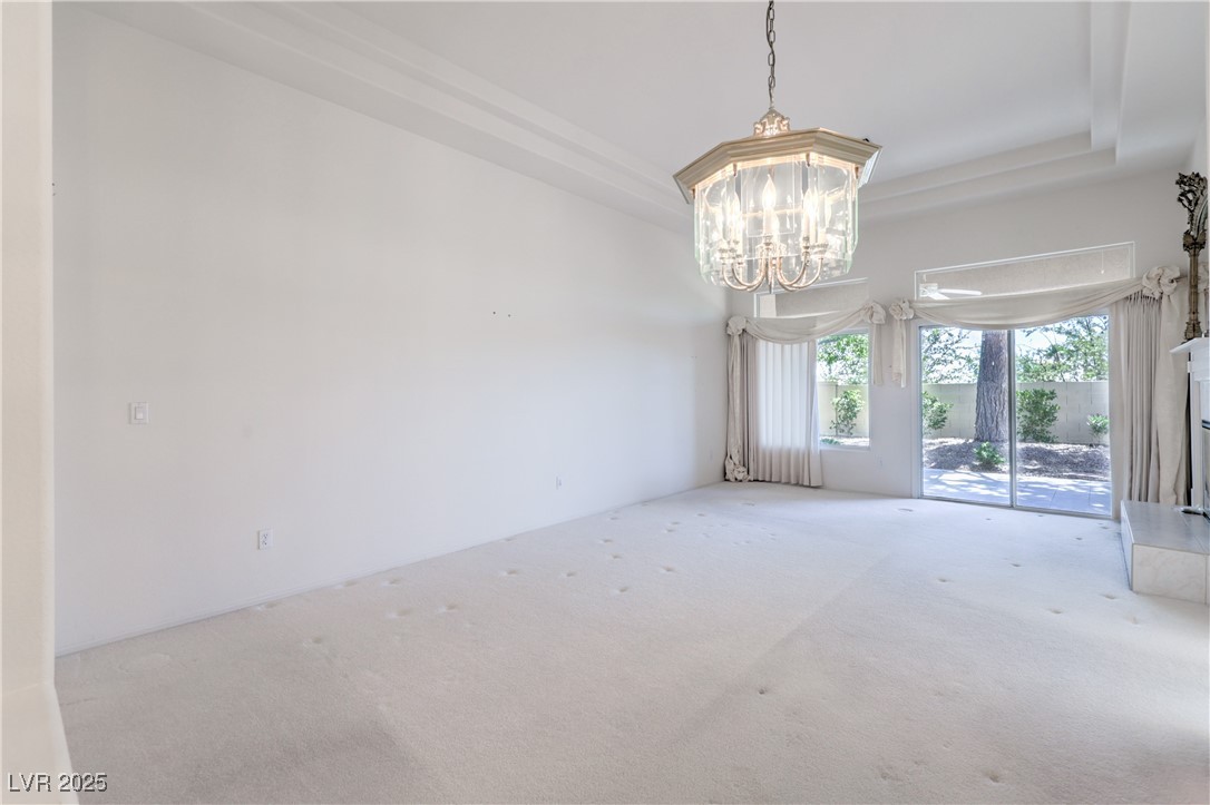 2404 Spring Water Drive Las Vegas, NV 89134 - Photo 11 of 27 Unfurnished room with carpet flooring, a chandelier, fireplace and a raised ceiling