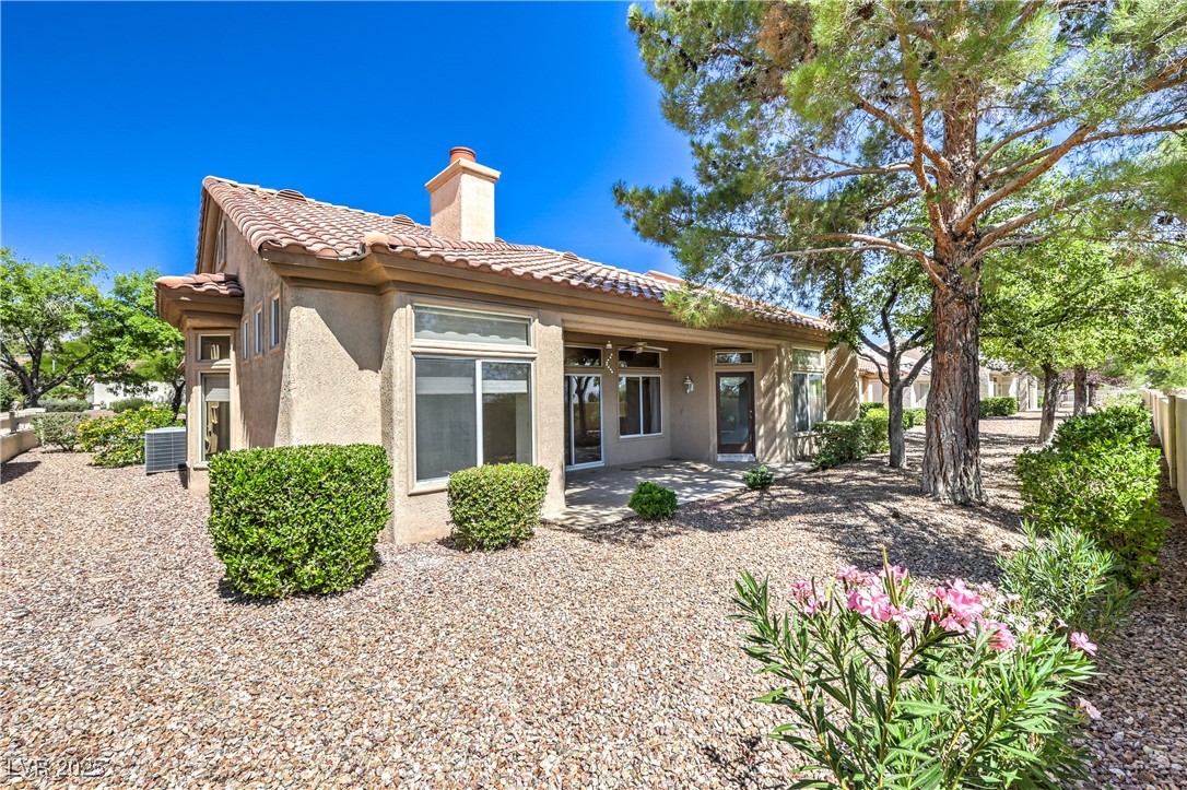 2404 Spring Water Drive Las Vegas, NV 89134 - Photo 24 of 27 Rear view of house with stucco siding, a chimney, and a tiled roof