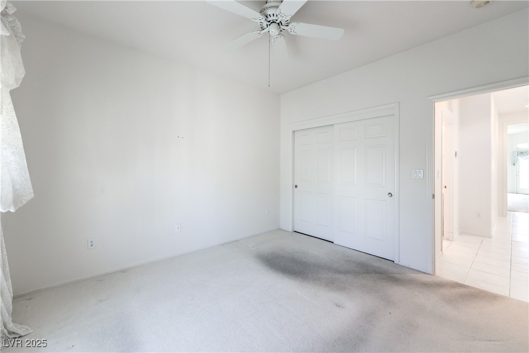 2404 Spring Water Drive Las Vegas, NV 89134 - Photo 26 of 27 Unfurnished bedroom with carpet flooring, a closet, and a ceiling fan