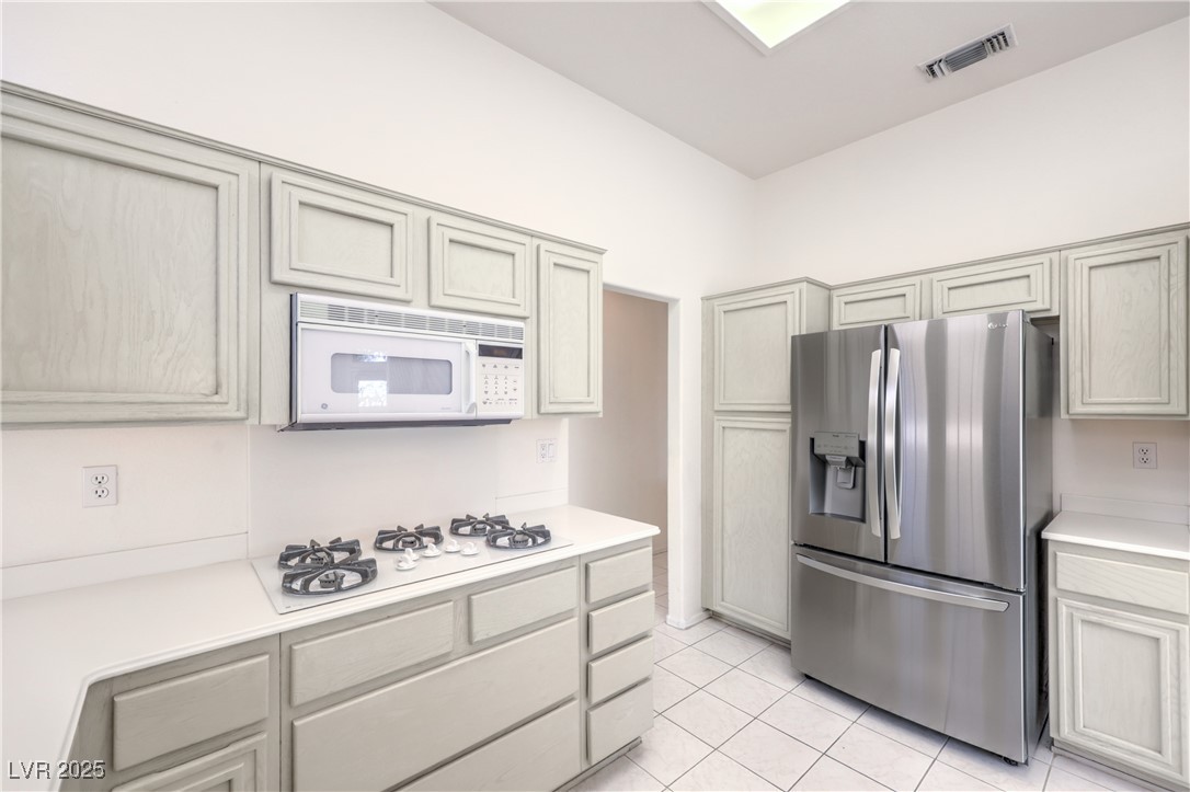 2404 Spring Water Drive Las Vegas, NV 89134 - Photo 6 of 27 Kitchen featuring white appliances, light countertops, and light tile patterned floors