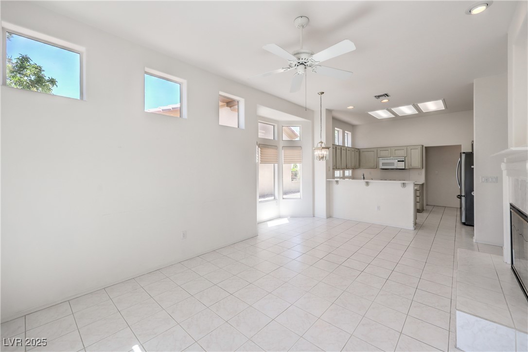 2404 Spring Water Drive Las Vegas, NV 89134 - Photo 8 of 27 Unfurnished kitchen area/family room with plenty of natural light, a ceiling fan, and a tile fireplace