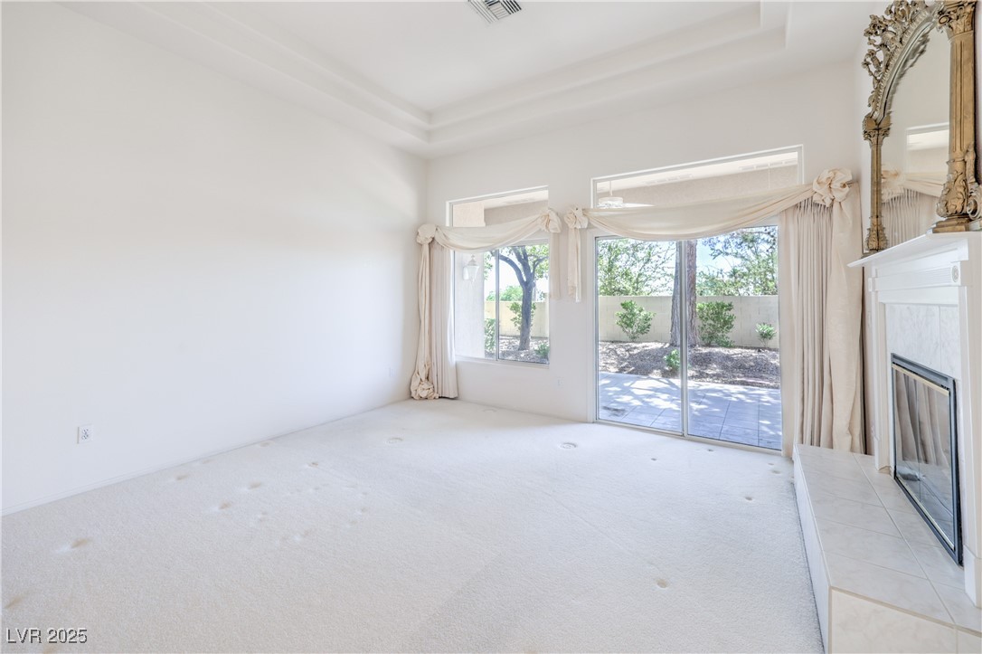 2404 Spring Water Drive Las Vegas, NV 89134 - Photo 10 of 27 Unfurnished living room featuring carpet, flooring,fireplace fireplace, and a raised ceiling
