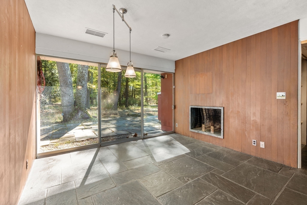 60 Baker Bridge Road Lincoln, MA 01773 - Photo 12 of 38 a living room with a fireplace and a floor to ceiling window