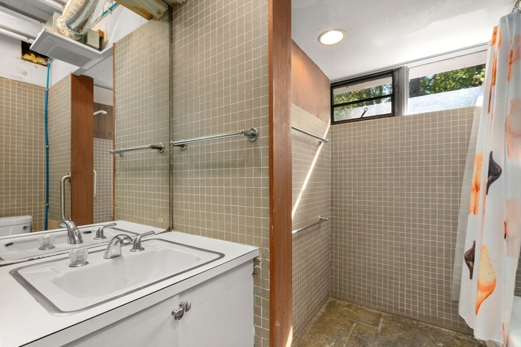 60 Baker Bridge Road Lincoln, MA 01773 - Photo 22 of 38 a bathroom with a sink a toilet and shower