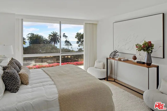 a bedroom with a bed and a large window