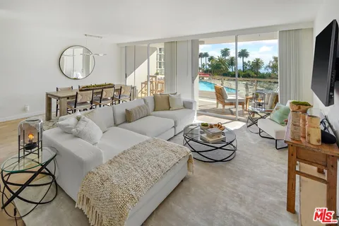 a living room with furniture a flat screen tv and a large window