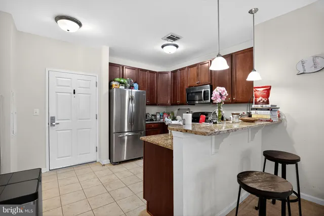 a kitchen with granite countertop a refrigerator stove and microwave