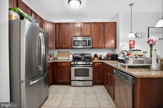 a very nice looking kitchen with granite countertop a sink cabinets and stainless steel appliances