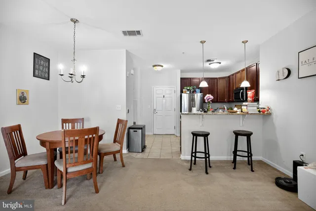 a view of a dining room with furniture a livingroom and chandelier