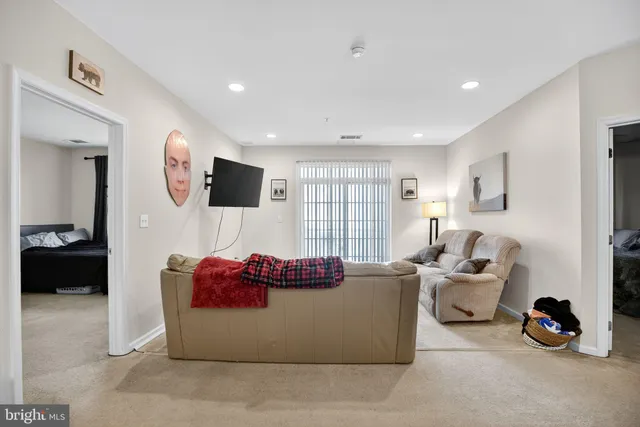a living room with furniture a flat screen tv and a large window