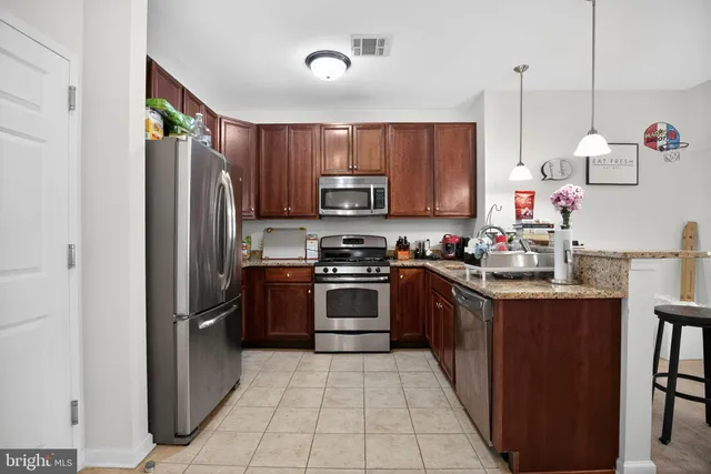a kitchen with stainless steel appliances a sink and a refrigerator