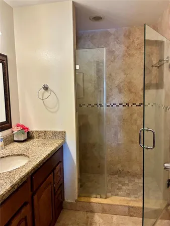 a bathroom with a granite countertop sink mirror and shower