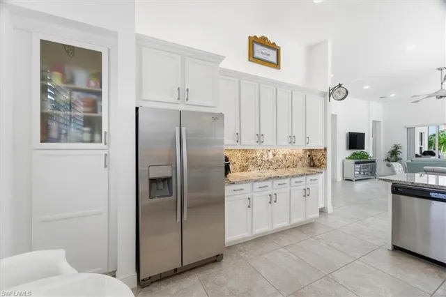 a kitchen with stainless steel appliances granite countertop a refrigerator and a stove top oven