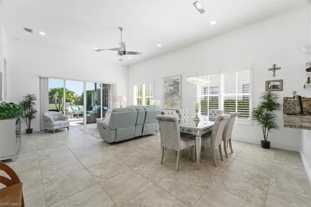 a dining room with furniture water view and a floor to ceiling window