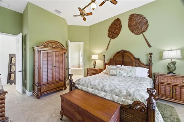 a bedroom with a bed and dresser with wooden floor