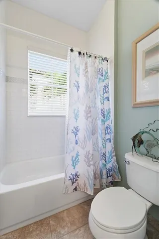 a white toilet sitting next to a bath tub