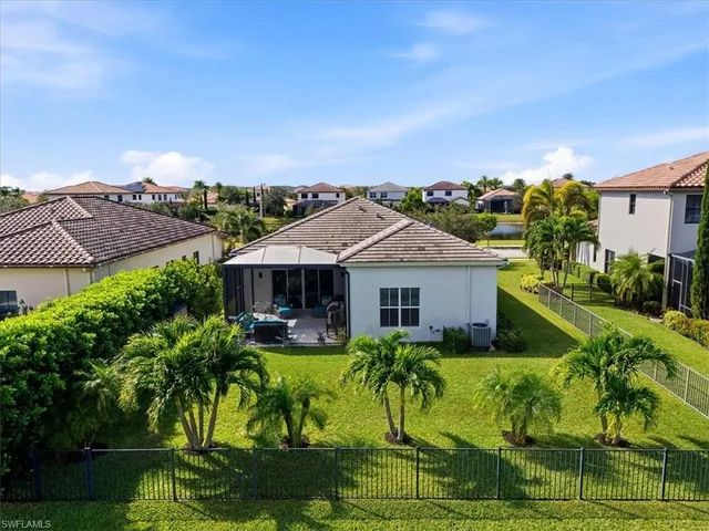 a view of a house with a big yard plants and large trees