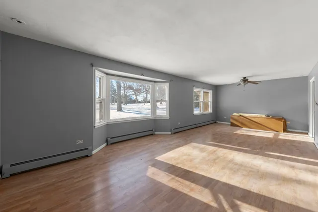 wooden floor in an empty room with a window