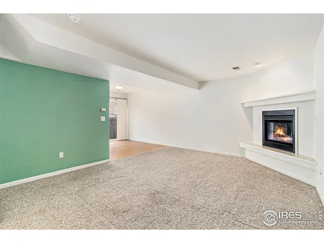a view of an empty room with a fireplace and a window