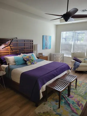 a bedroom with bed and wooden floor