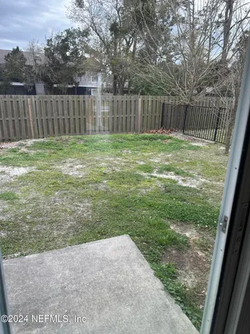 a view of backyard with wooden fence