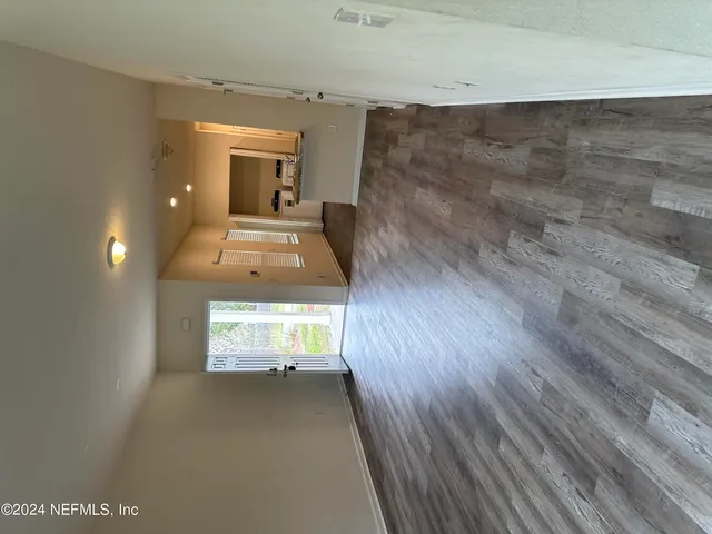 a view of a hallway with wooden floor and a fireplace