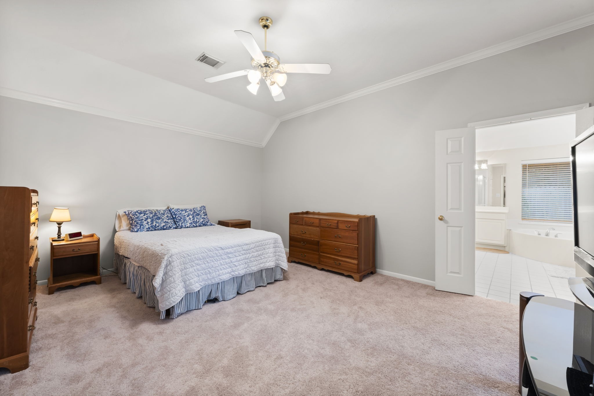 1614 Mercoal Drive Spring, TX 77386 - Photo 22 of 50 This large primary bedroom with recently updated flooring, invites rest and relaxation, featuring high ceilings, bright open space, and an ensuite bath that enhances everyday comfort.