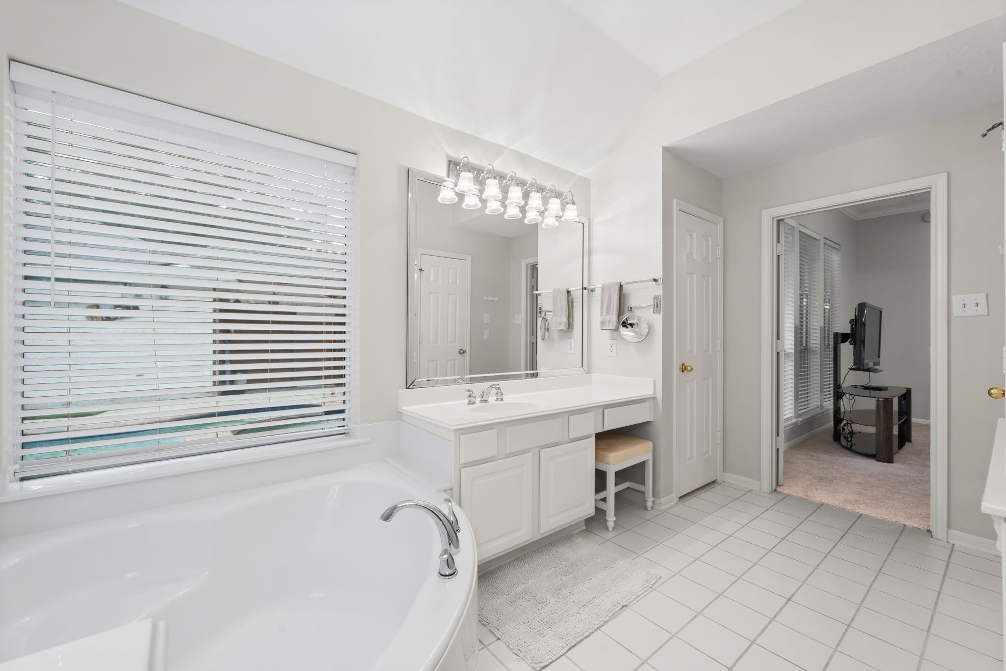 1614 Mercoal Drive Spring, TX 77386 - Photo 27 of 50 Enjoy a master bath that’s both relaxing and functional, featuring a deep soaking tub, vanity with seating, and a linen closet for easy access to essentials.