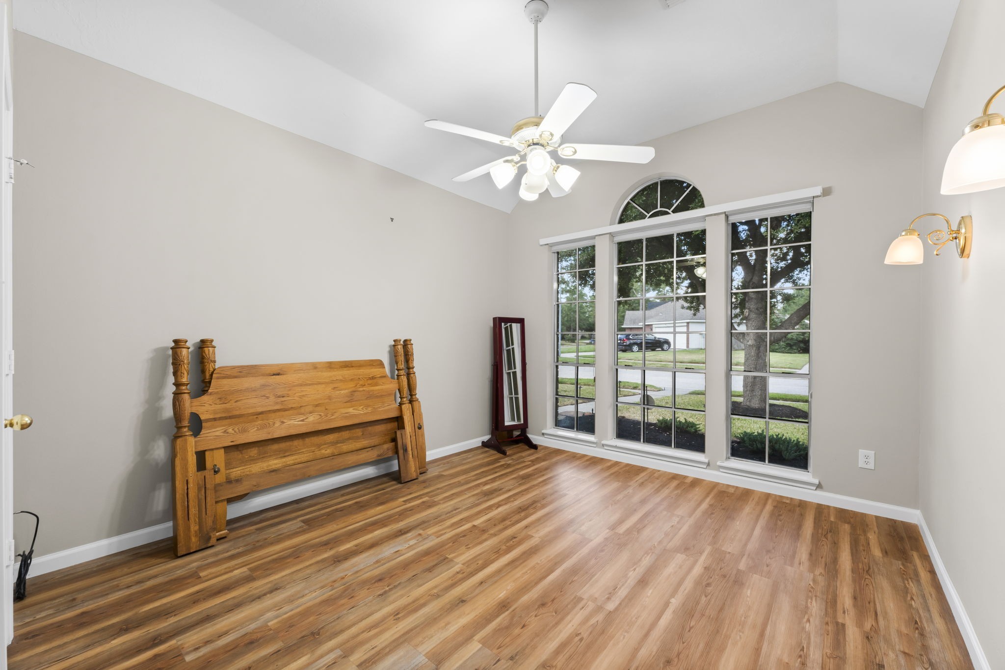 1614 Mercoal Drive Spring, TX 77386 - Photo 32 of 50 The spacious guest bedroom features warm wood floors and large windows overlooking the front yard, creating a bright, inviting space perfect for family, kids, guests—or easily converted into a comfortable home office.