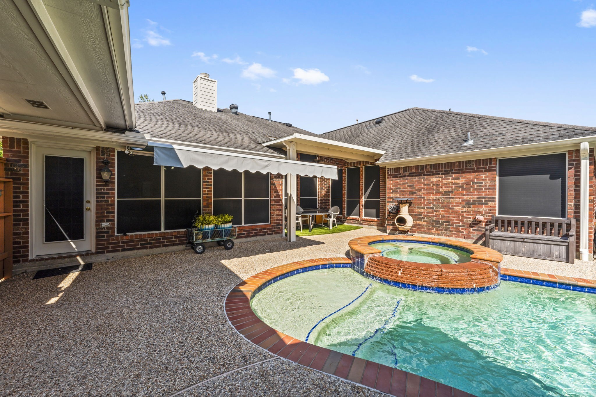 1614 Mercoal Drive Spring, TX 77386 - Photo 34 of 50 Enjoy the backyard oasis from a patio with a retractable cover, providing flexible shade while overlooking the sparkling pool and spa.