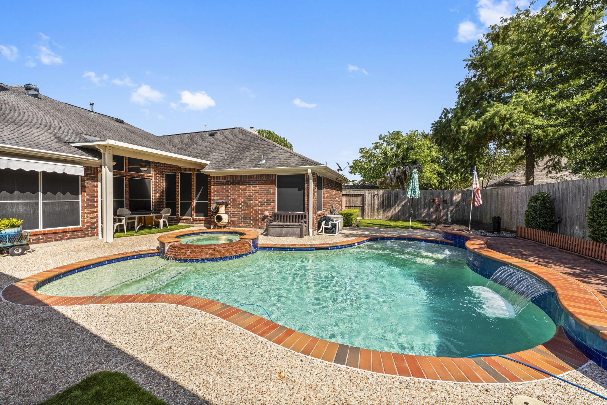 1614 Mercoal Drive Spring, TX 77386 - Photo 35 of 50 Enjoy the privacy of a backyard oasis with a heated saltwater pool, cascading waterfall, playful jets, and a spa, perfect for family fun and peaceful moments alike.