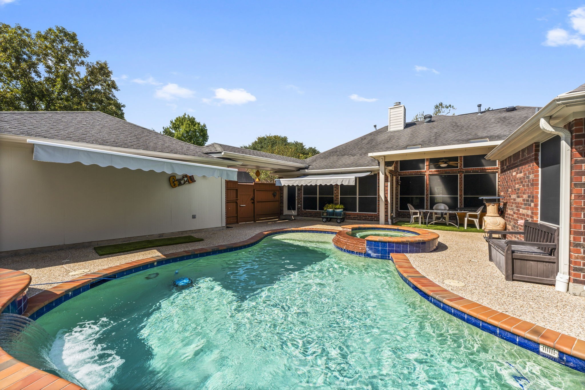 1614 Mercoal Drive Spring, TX 77386 - Photo 38 of 50 Enjoy flexible outdoor living with retractable awnings that offer shade when needed and open-air sunshine when desired, creating a comfortable space for the pool and patio.
