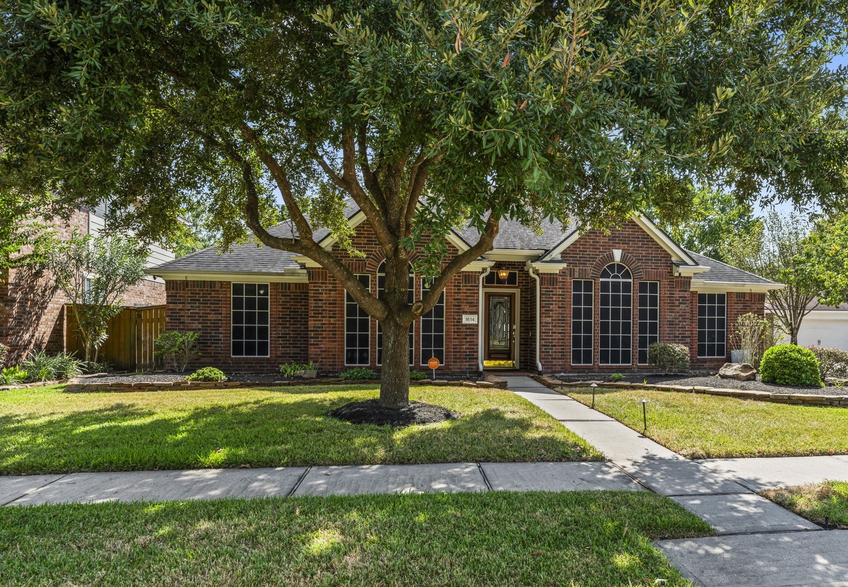 1614 Mercoal Drive Spring, TX 77386 - Photo 48 of 50 A mature shade tree graces the front yard, providing dappled sunlight, natural beauty, and a welcoming touch that enhances the home’s curb appeal.