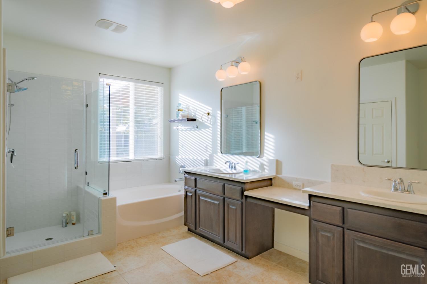 Undisclosed Address Bakersfield, CA 93314 - Photo 37 of 47 a spacious bathroom with a granite countertop sink mirror and shower