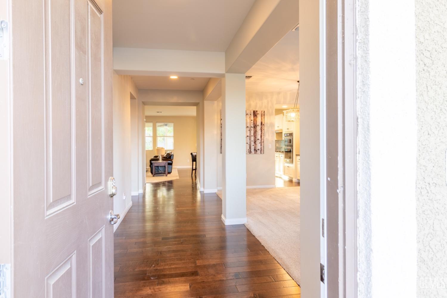 Undisclosed Address Bakersfield, CA 93314 - Photo 4 of 47 a view of a hallway with wooden floor a livingroom and a living room