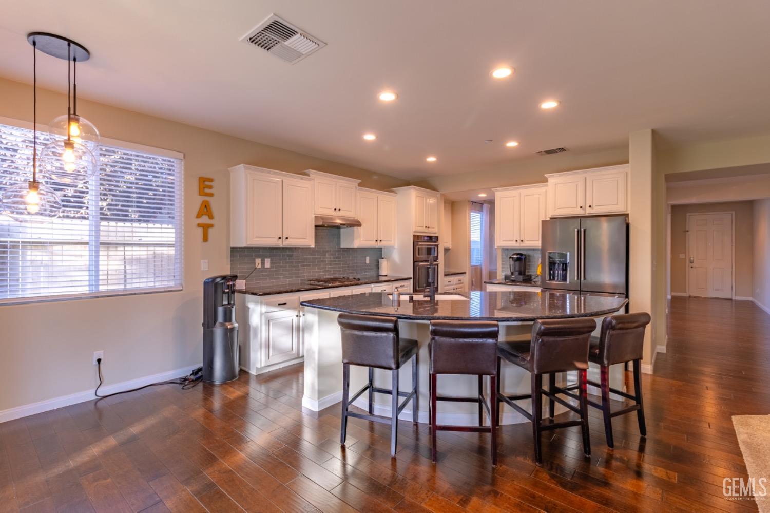 Undisclosed Address Bakersfield, CA 93314 - Photo 9 of 47 a kitchen with stainless steel appliances kitchen island granite countertop a dining table chairs and granite counter tops