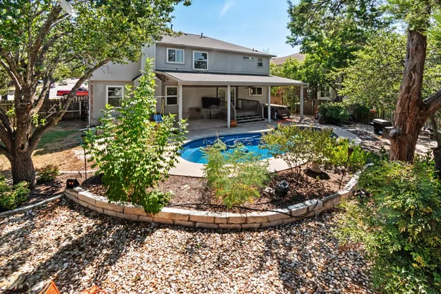 a view of a house with a yard and potted plants