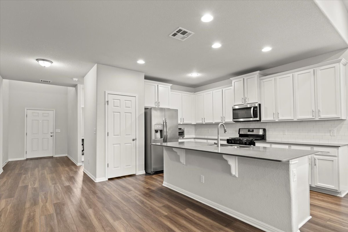 213 Munk Lane Leander, TX 78641 - Photo 5 of 40 a kitchen with stainless steel appliances a refrigerator sink and microwave