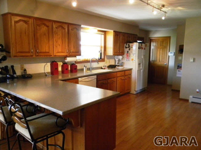 1181-17 17 1/2 Road Fruita, CO 81521 - Photo 25 of 38 a kitchen with a refrigerator a sink dishwasher and wooden cabinets with a large window