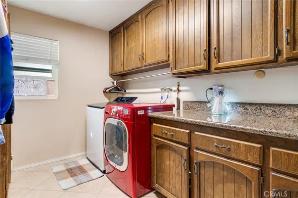 a utility room with granite countertop cabinets washer and dryer
