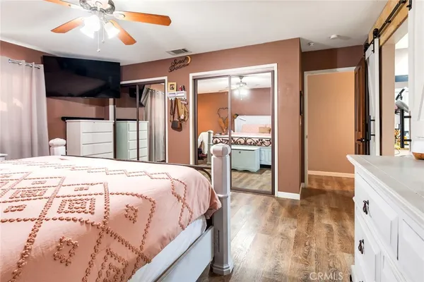 a spacious bedroom with a large bed and a chandelier