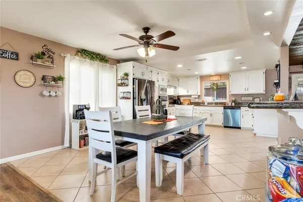 a kitchen with a dining table chairs and refrigerator