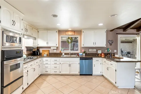a kitchen with granite countertop white cabinets and white appliances