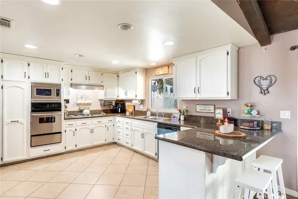 a kitchen with white cabinets stainless steel appliances and sink