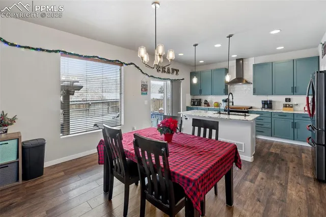 a kitchen that has a table chairs and wooden floor
