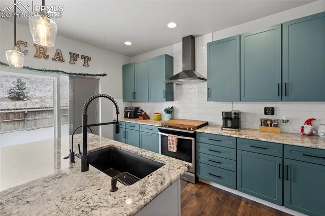 a kitchen with stainless steel appliances kitchen island granite countertop a sink refrigerator and cabinets