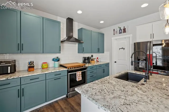 a kitchen with stainless steel appliances granite countertop a kitchen island a stove and a refrigerator
