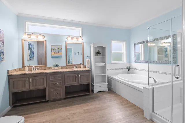 a spacious bathroom with a tub sink and mirror