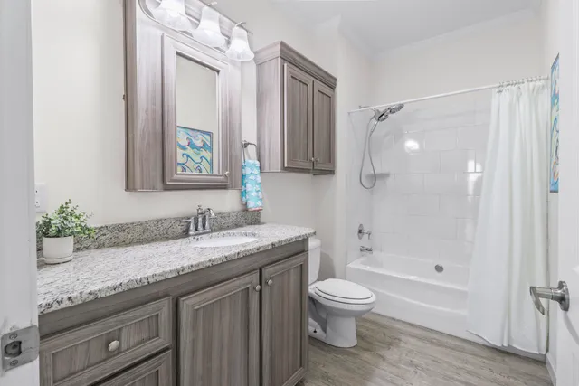 a bathroom with a granite countertop sink toilet a large mirror a shower and a bathtub